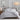 Sferra bedding set in a soft grey hue, showcasing the brand's signature craftsmanship with smooth, finely woven fabric, styled in a modern, cozy bedroom.