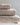 Stack of plush beige towels in varying sizes, neatly arranged on a marble surface.