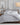 Sferra bedding set in a soft grey hue, showcasing the brand's signature craftsmanship with smooth, finely woven fabric, styled in a modern, cozy bedroom.