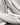 Close-up of luxurious jacquard fabric in a soft neutral tone, showcasing its intricate woven texture and elegant, raised pattern.